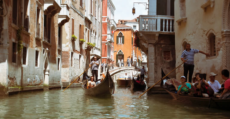 Un gondolier avec des touristes dans un canal de Venise