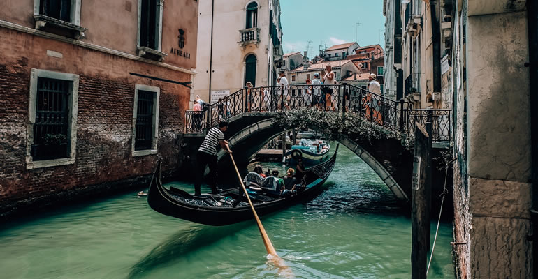 Un gondoliere con turisti in un canale di Venezia